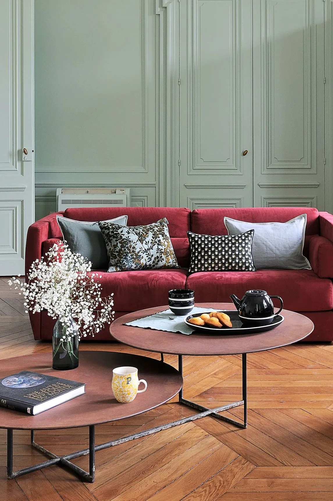 Un canapé en velours rouge dans un intérieur vert sapin claire